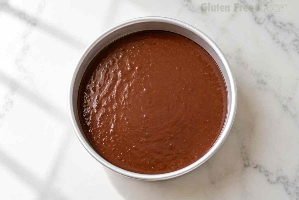 Chocolate cake batter evenly divided between two round cake pans