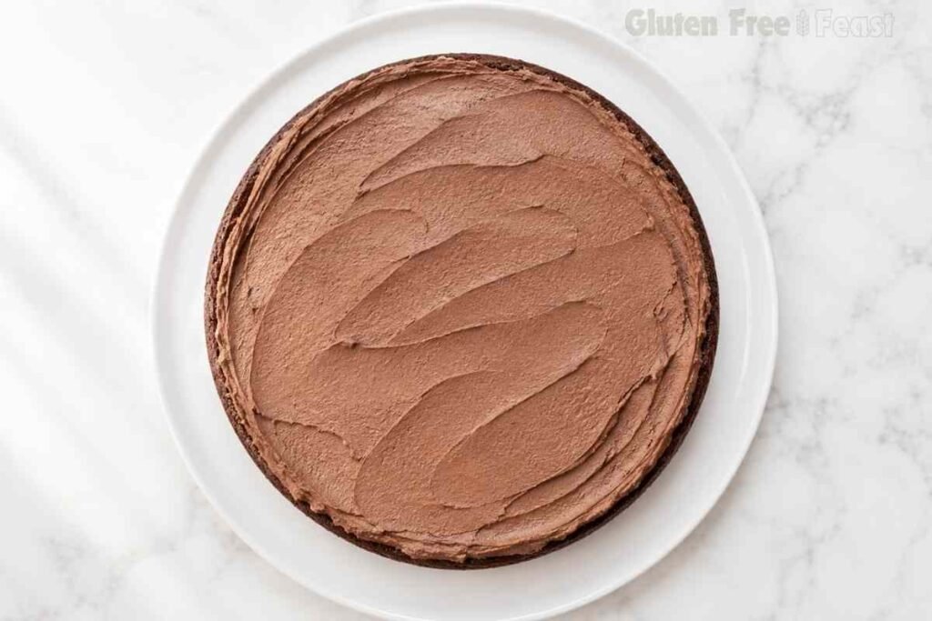 Chocolate buttercream spread over the first cake layer