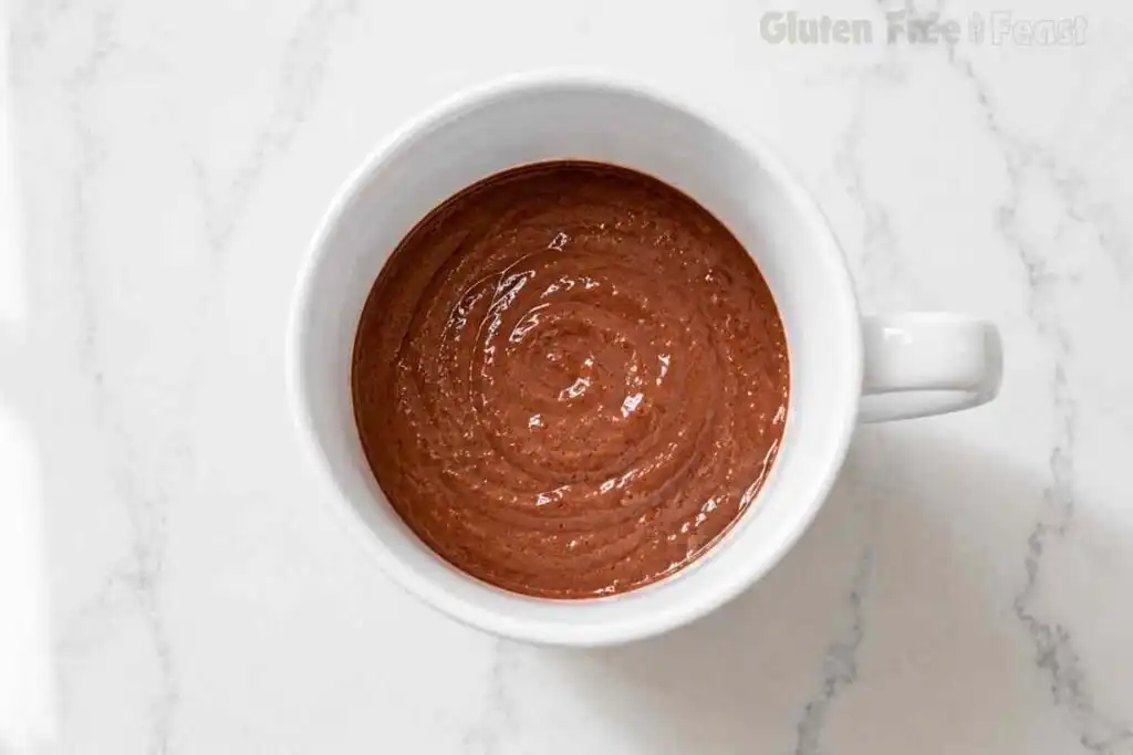Smooth chocolate mug cake batter in a white ceramic mug