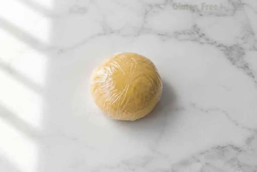 Smooth gluten-free pasta dough ball on white marble