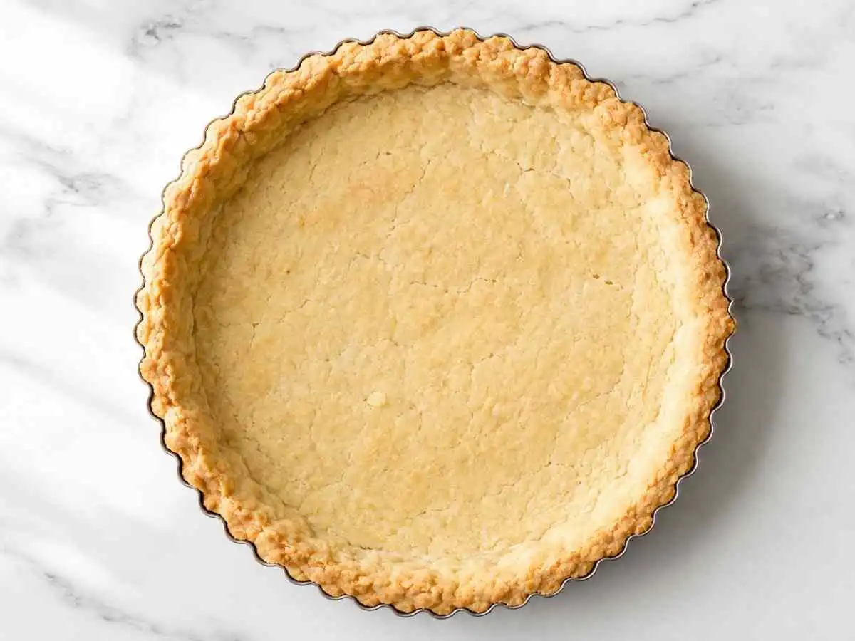 Golden homemade gluten free pie crust in a fluted tart pan