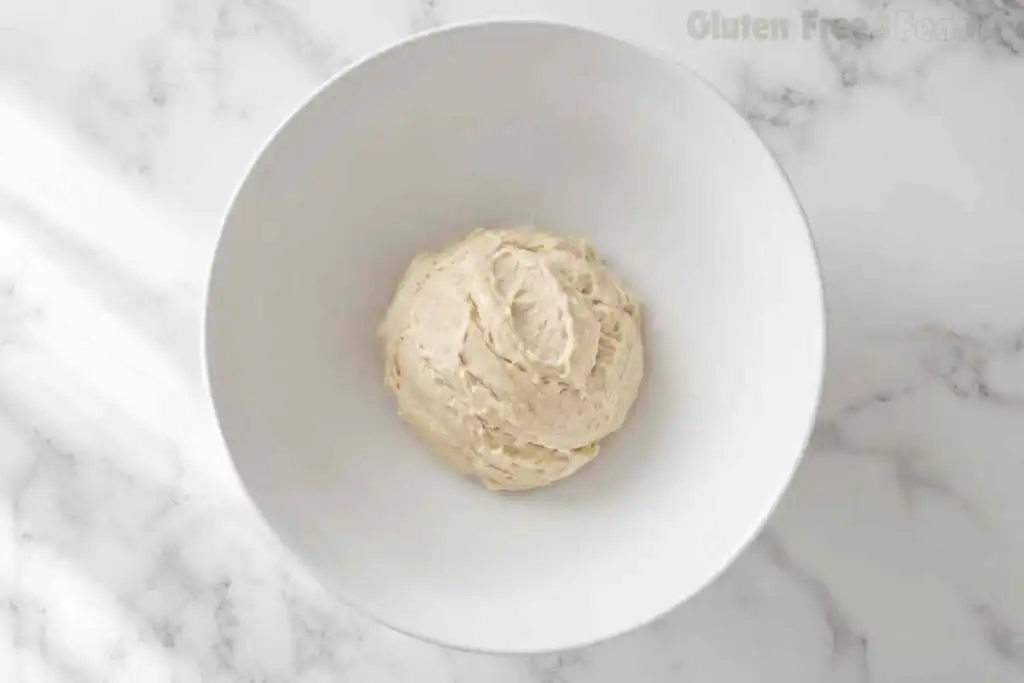 Freshly mixed gluten free pie dough in a white mixing bowl