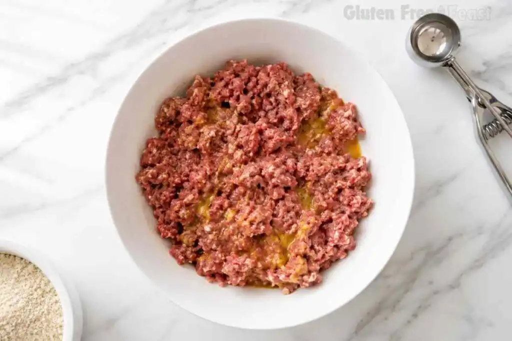 Raw ground beef mixture with gluten free breadcrumbs, eggs, milk, and seasonings