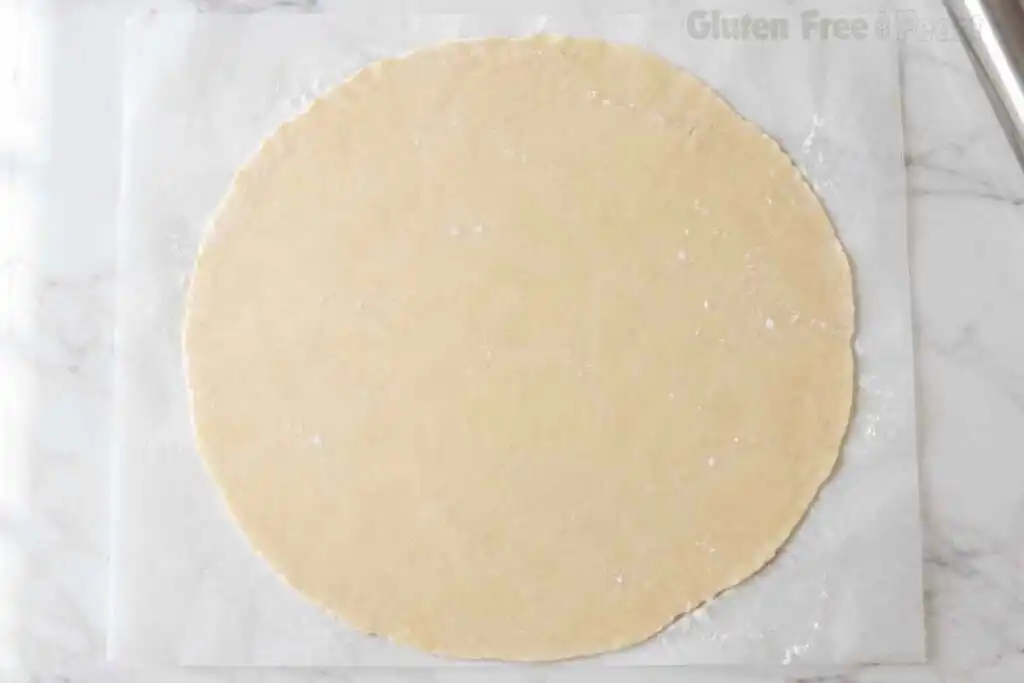 Rolled gluten free pie dough on parchment paper