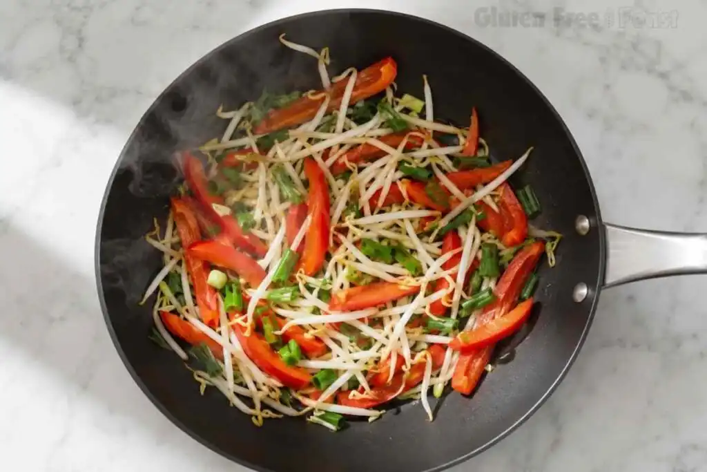Colorful vegetables cooking together for an easy gluten free pad thai dinner.