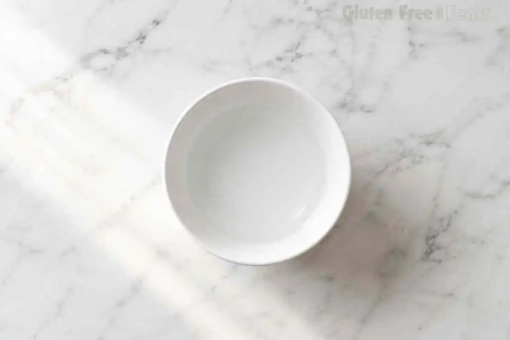 Small bowl of warm water used to make gluten free pizza dough