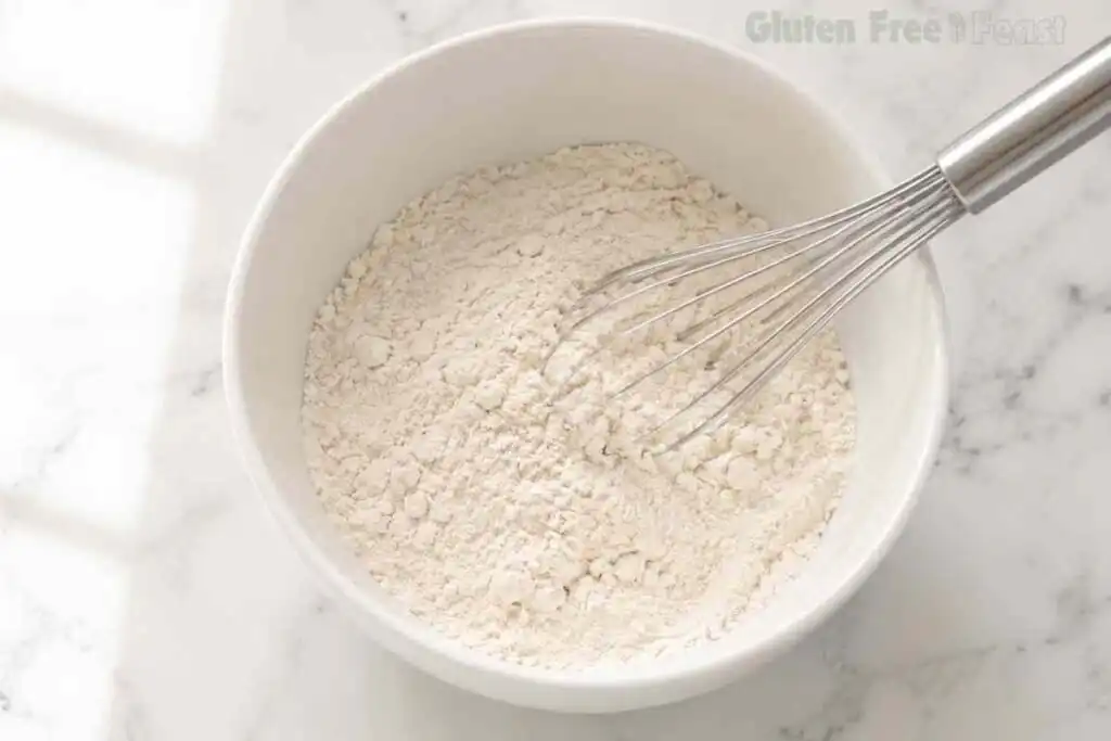 Whisking gluten free flour and dry ingredients in a white bowl