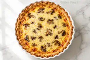 Overhead view of whole baked gluten free mushroom Gruyere quiche in white ceramic pie dish on marble surface