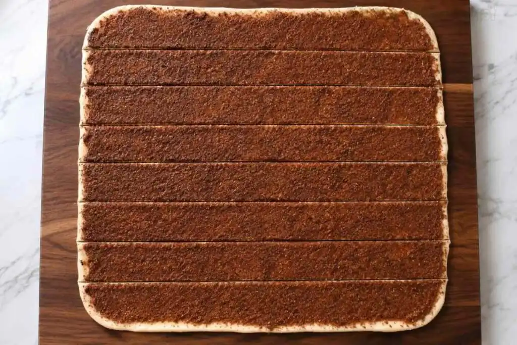 Gluten free cinnamon roll dough covered with cinnamon sugar filling