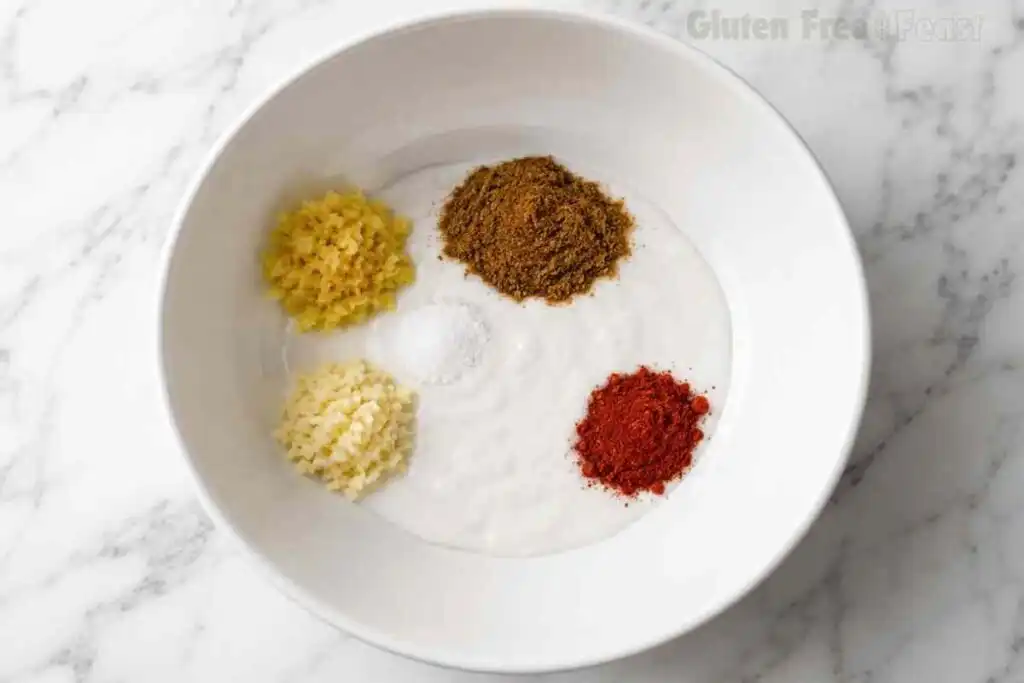 Coconut cream, garlic, ginger, garam masala, chili powder, and salt in a mixing bowl