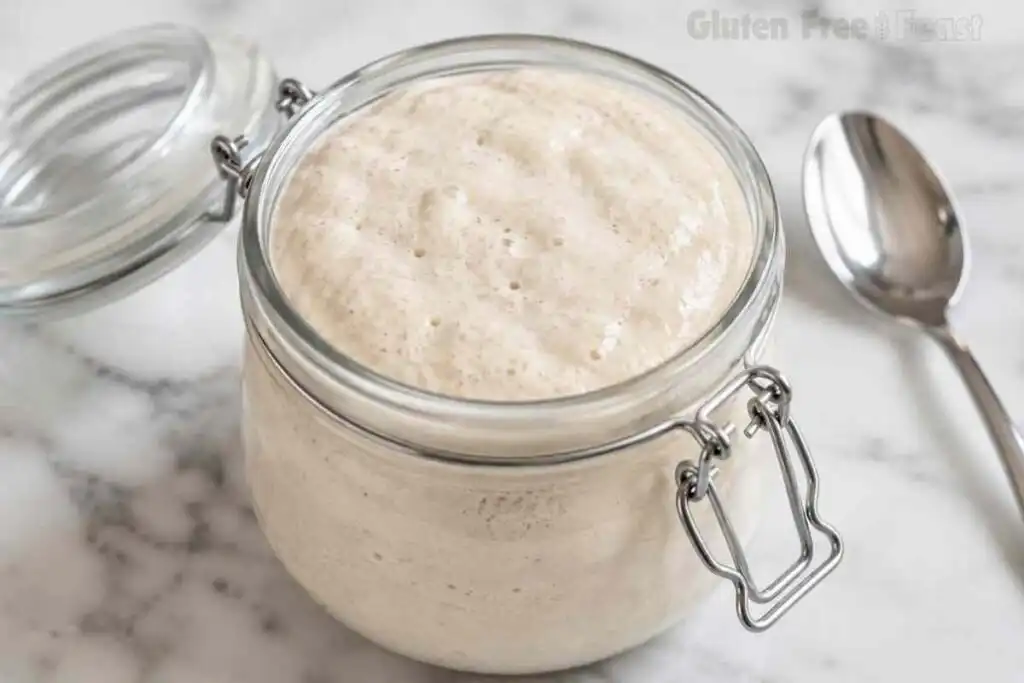Close-up of bubbly gluten free sourdough starter filling a glass jar after successful fermentation.