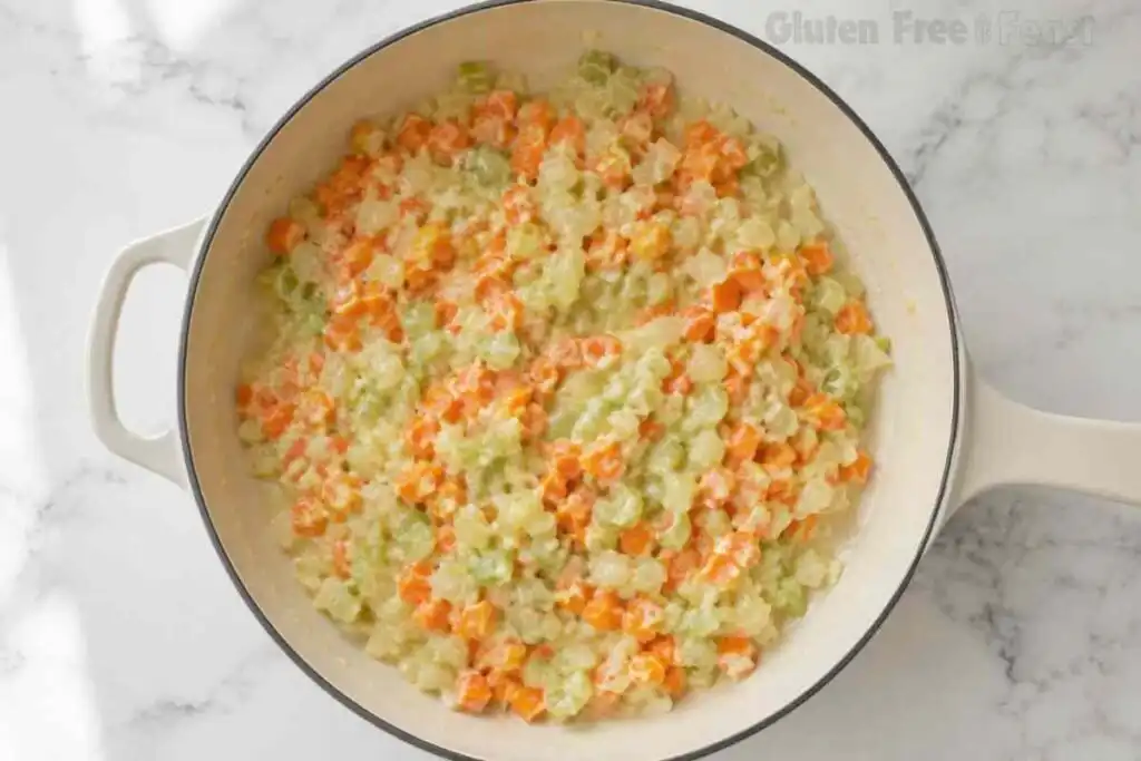 Vegetables coated in gluten-free flour roux inside a skillet