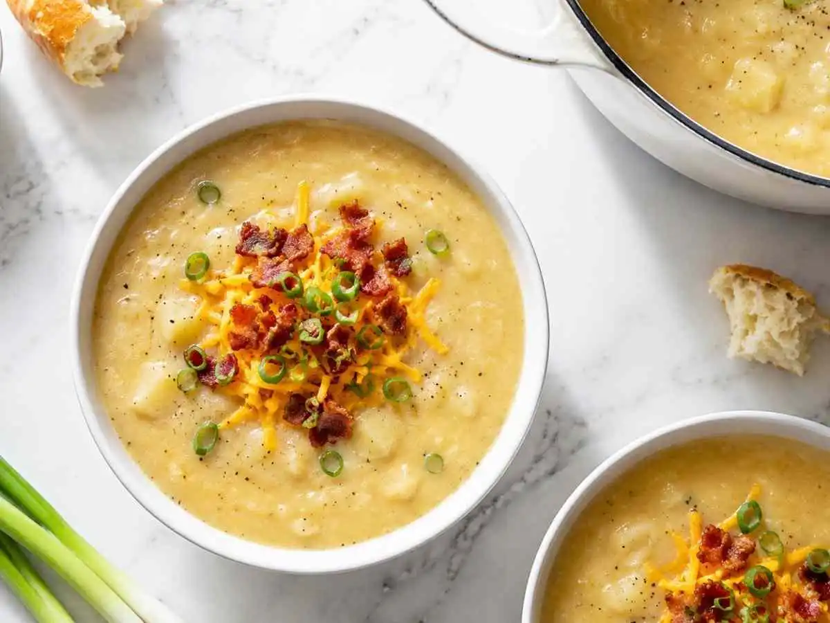 Creamy homemade gluten free potato soup served with bread and Dutch oven