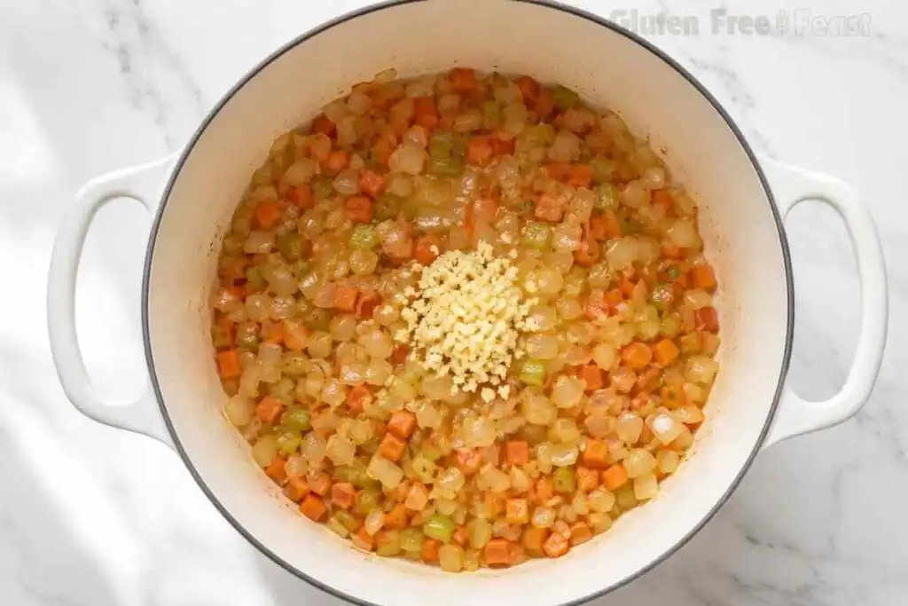 Onion, carrot, celery, and garlic sautéing in a Dutch oven