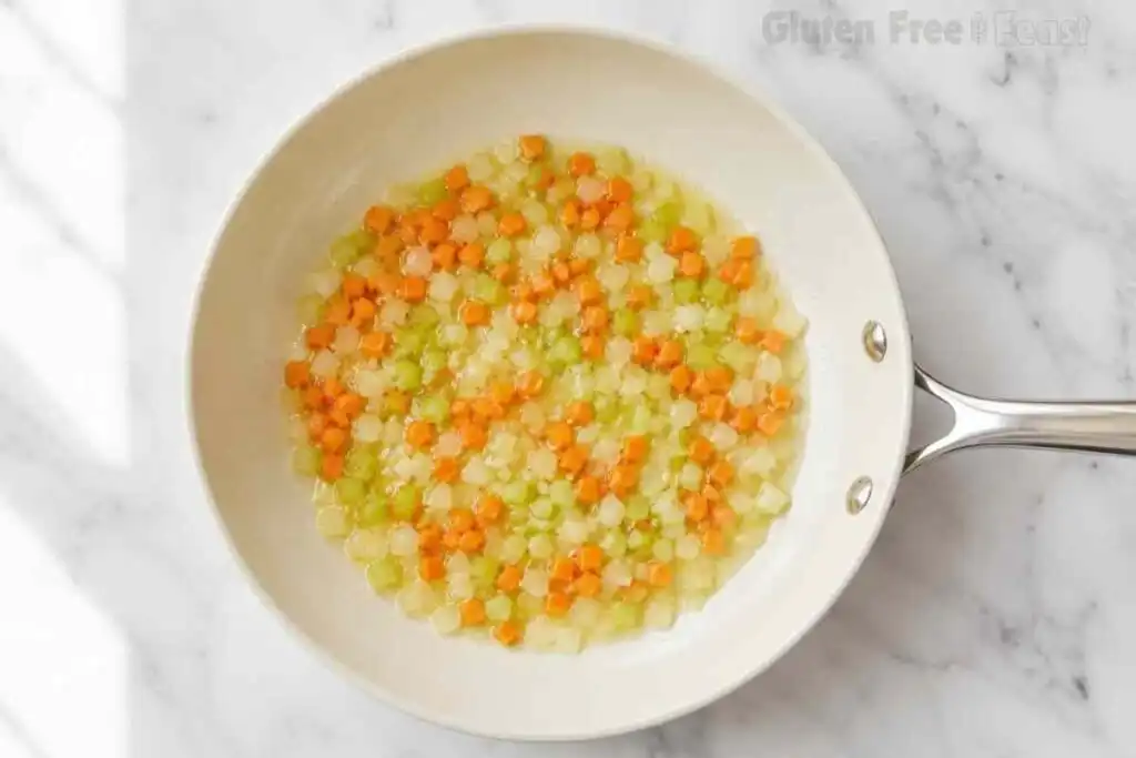 Carrots, celery, onions, and butter cooking in a skillet