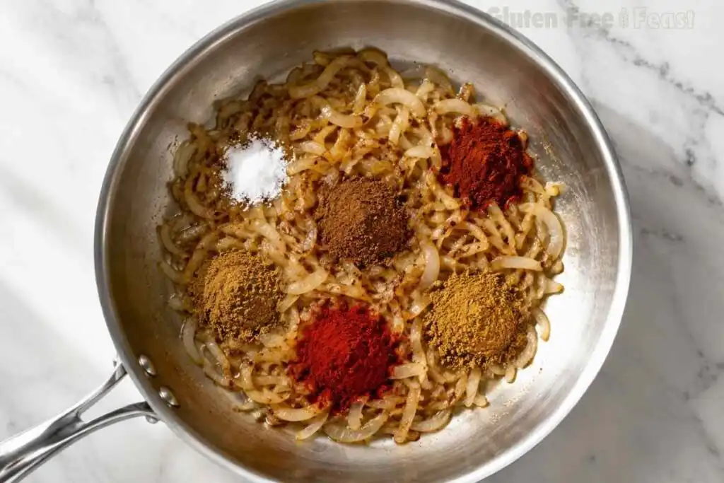 Garam masala, cumin, coriander, paprika, chili powder, and salt added to onions