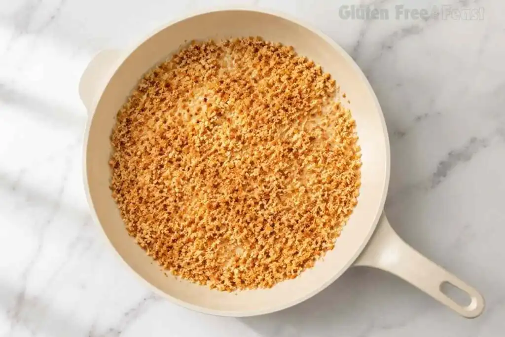 Golden toasted gluten-free panko breadcrumbs in a cream-colored skillet
